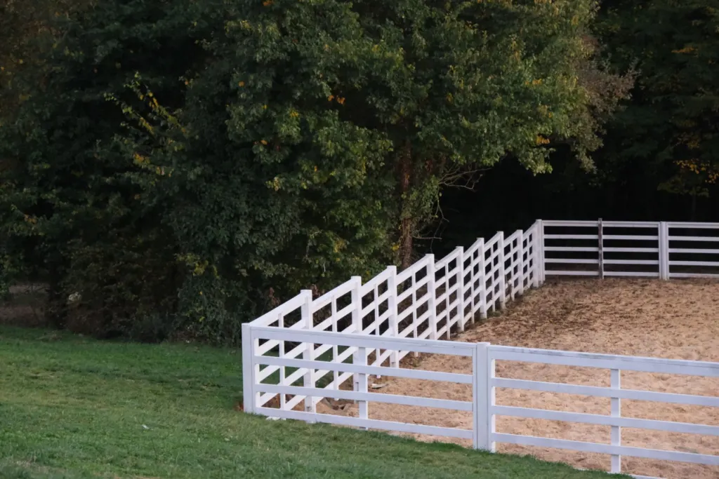 White four-rail fence around a yard