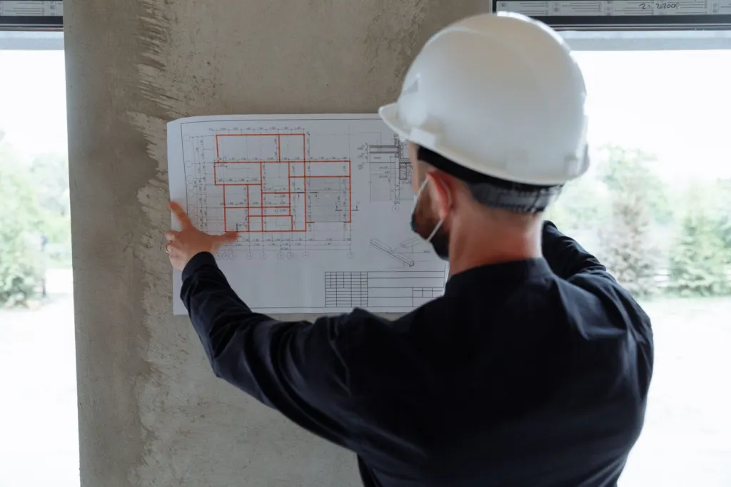 Contractor in a hard hat reviewing a floor plan