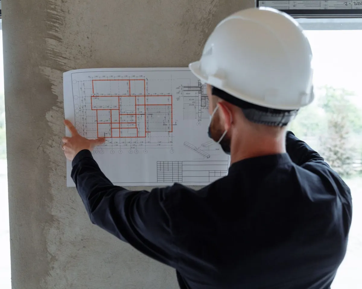 Contractor in a hard hat reviewing a floor plan
