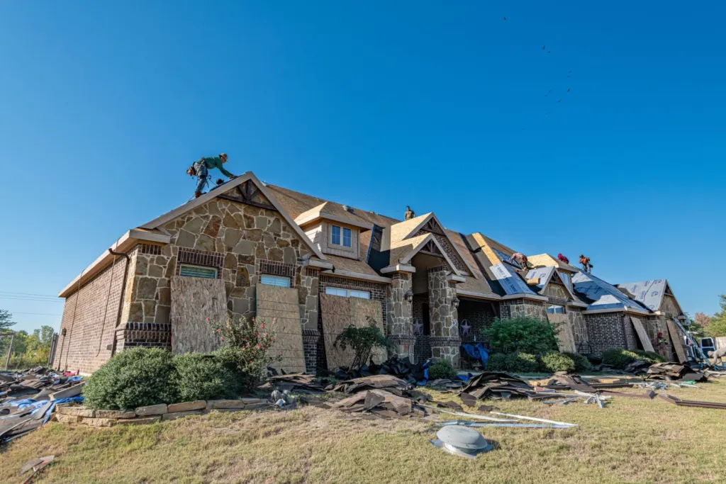 Roofing crew replacing the roof on a stone and brick house